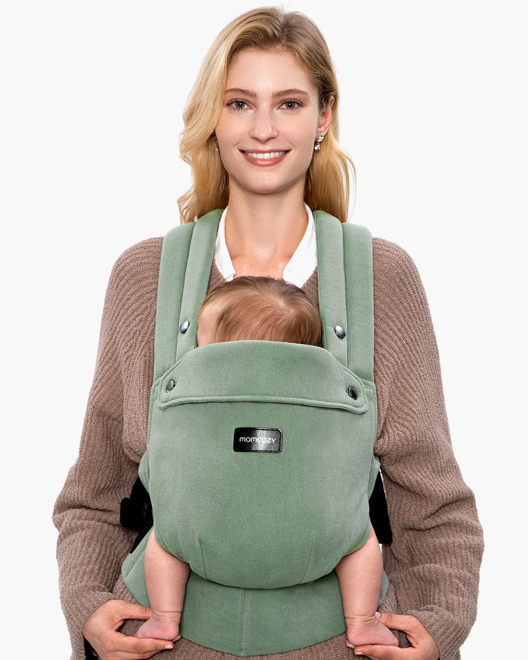 Translation missing: en.Momcozy PureHug baby carrier in sage green, babywearing comfortably. Mother and baby are smiling